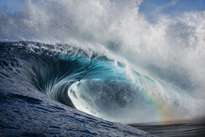 wave breaking with a rainbow in foreground